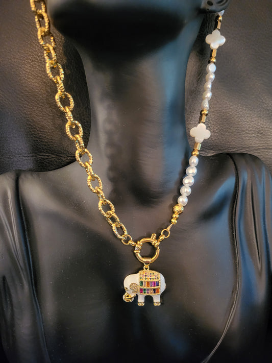 Collier Fantasia White avec pendentif éléphant laqué blanc, plaqué or, micropavé de cristaux multicolores, trèfles en nacre et perles de culture naturelles.